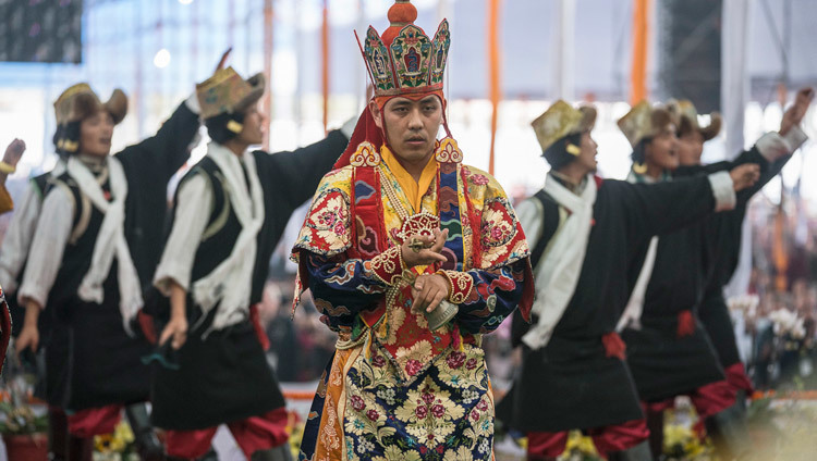 A group singing a traditional song behind on of the Namgyal Monastery monks performing the Kalalachakra Ritual Offering Dance at the Kalachakra Temple in Bodhgaya, Bihar, India on January 9, 2017. Photo/Tenzin Choejor/OHHDL A group singing a traditional song behind on of the Namgyal Monastery monks performing the Kalalachakra Ritual Offering Dance at the Kalachakra Temple in Bodhgaya, Bihar, India on January 9, 2017. Photo/Tenzin Choejor/OHHDL