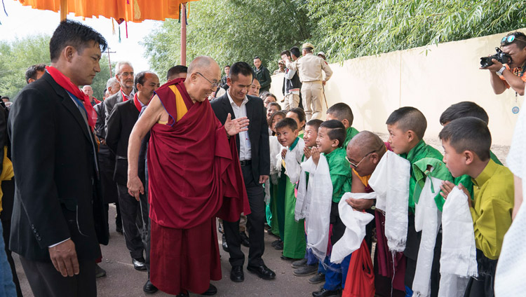 His Holiness the Dalai Lama greeting young students on his way to the Shiwatsel teaching ground in Leh, Ladakh, J&K, India on July 6, 2017. Photo by Tenzin Choejor/OHHDL