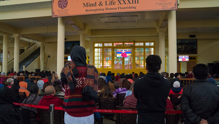 Members of the public watching His Holiness the Dalai Lama on TVs in the courtyard of the Main Tibetan Temple on the fourth day of the Mind & Life Conference in Dharamsala, HP, India on March 15, 2018. Photo by Tenzin Choejor Members of the public watching His Holiness the Dalai Lama on TVs in the courtyard of the Main Tibetan Temple on the fourth day of the Mind & Life Conference in Dharamsala, HP, India on March 15, 2018. Photo by Tenzin Choejor