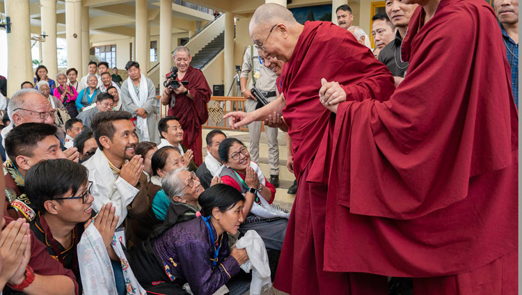 His Holiness the Dalai Lama greeting members of the audience as he departs for his residence at the conclusion of his meeting with participants to an International Conference on the Middle Way Approach at the Main Tibetan Temple courtyard in Dharamsala, HP, India on May 30, 2018. Photo by Tenzin Choejor His Holiness the Dalai Lama greeting members of the audience as he departs for his residence at the conclusion of his meeting with participants to an International Conference on the Middle Way Approach at the Main Tibetan Temple courtyard in Dharamsala, HP, India on May 30, 2018. Photo by Tenzin Choejor
