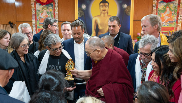 The audience gathers around His Holiness the Dalai Lama as he presents a Dharma Wheel to Deepak Chopra at the conclusion of their meeting in Dharamsala, HP, India on February 11, 2019. Photo by Tenzin Choejor The audience gathers around His Holiness the Dalai Lama as he presents a Dharma Wheel to Deepak Chopra at the conclusion of their meeting in Dharamsala, HP, India on February 11, 2019. Photo by Tenzin Choejor