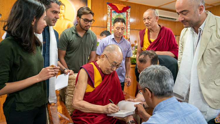 His Holiness the Dalai Lama signing one of his books to present to members of a group from Iran at the conclusion of their meeting at his residence in Dharamsala, HP, India on June 7, 2019. Photo by Tenzin Choejor His Holiness the Dalai Lama signing one of his books to present to members of a group from Iran at the conclusion of their meeting at his residence in Dharamsala, HP, India on June 7, 2019. Photo by Tenzin Choejor