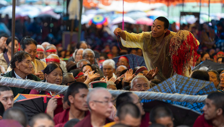 A volunteer passing out ritual protection cords as His Holiness the Dalai Lama gives the Empowerment of Mahakarunika Lokeshvara in Manali, HP, India on August 17, 2019. Photo by Tenzin Choejor A volunteer passing out ritual protection cords as His Holiness the Dalai Lama gives the Empowerment of Mahakarunika Lokeshvara in Manali, HP, India on August 17, 2019. Photo by Tenzin Choejor