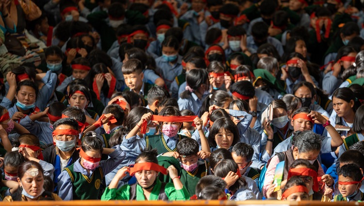 Students in the crowd wearing ritual red blindfolds as part of taking the Avalokiteshvara Empowerment conferred by His Holiness the Dalai Lama at the Main Tibetan Temple in Dharamsala, HP, India on June 2, 2022. Photo by Tenzin Choejor Students in the crowd wearing ritual red blindfolds as part of taking the Avalokiteshvara Empowerment conferred by His Holiness the Dalai Lama at the Main Tibetan Temple in Dharamsala, HP, India on June 2, 2022. Photo by Tenzin Choejor