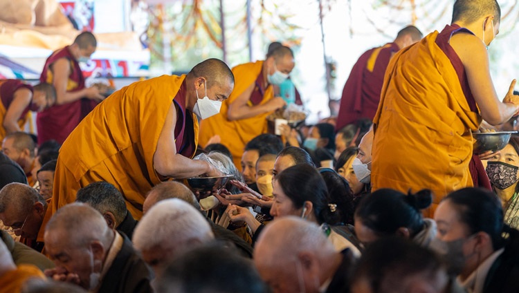 Monks distributing ritual pills to members of the audience during the permission of 21 Taras on the third day of His Holiness the Dalai Lama's teachings at the Kalachakra Teaching Ground in Bodhgaya, Bihar, India on December 31, 2022. Photo by Tenzin Choejor Monks distributing ritual pills to members of the audience during the permission of 21 Taras on the third day of His Holiness the Dalai Lama's teachings at the Kalachakra Teaching Ground in Bodhgaya, Bihar, India on December 31, 2022. Photo by Tenzin Choejor