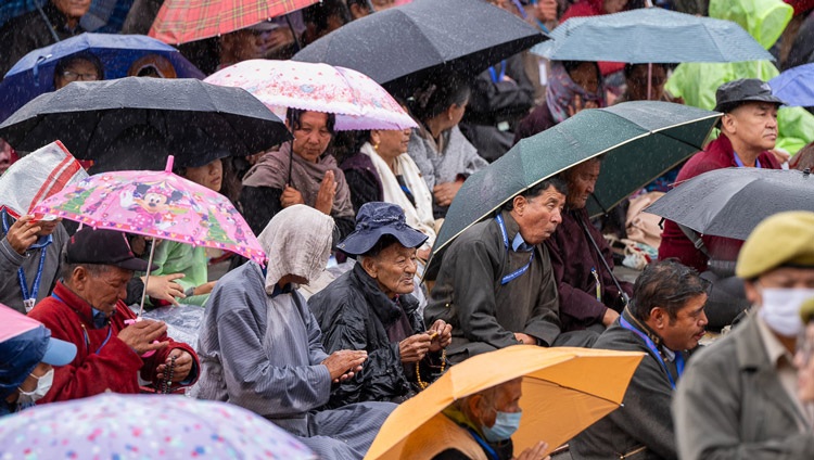 Members of the crowd, many protecting themselves against the rain, listening to His Holiness the Dalai Lama as he confers the Avalokiteshvara Empowerment at the Shewatsel Teaching Ground in Leh, Ladakh, India on July 23, 2023. Photo by Tenzin Choejor Members of the crowd, many protecting themselves against the rain, listening to His Holiness the Dalai Lama as he confers the Avalokiteshvara Empowerment at the Shewatsel Teaching Ground in Leh, Ladakh, India on July 23, 2023. Photo by Tenzin Choejor