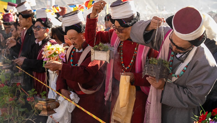 Members of the crowd lining the road holding flowers and burning incense waiting to welcome His Holiness the Dalai Lama to arrive at the teaching ground in Khaltse, Ladakh, India on August 19, 2023. Photo by Tenzin Choejor Members of the crowd lining the road holding flowers and burning incense waiting to welcome His Holiness the Dalai Lama to arrive at the teaching ground in Khaltse, Ladakh, India on August 19, 2023. Photo by Tenzin Choejor