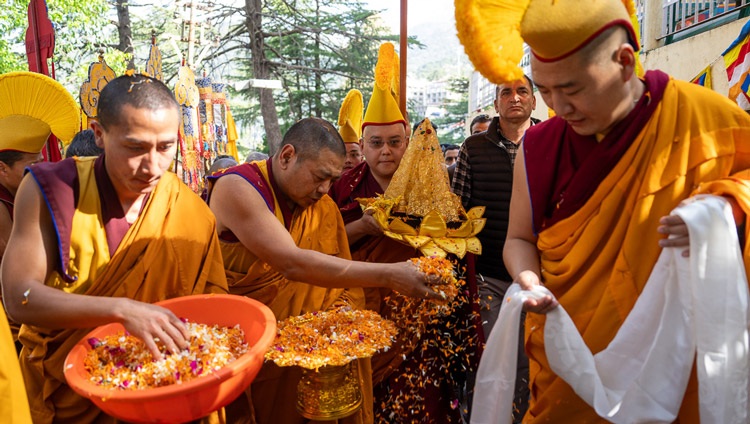 Monks scattering flower petals lead the way as the relics of the Buddha are carried up the drive of the Main Tibetan Temple to offer to His Holiness the Dalai Lama waiting at the gate to his residence in Dharamsala, HP, India on April 4, 2024. Photo by Tenzin Choejor Monks scattering flower petals lead the way as the relics of the Buddha are carried up the drive of the Main Tibetan Temple to offer to His Holiness the Dalai Lama waiting at the gate to his residence in Dharamsala, HP, India on April 4, 2024. Photo by Tenzin Choejor