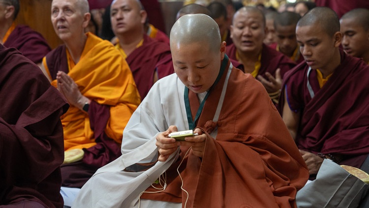 A member of the audience listening to an interpretation of His Holiness the Dalai Lama on FM radio during the Mahakala permission at the Main Tibetan Temple in Dharamsala, HP, India on May 18, 2024. Photo by Tenzin Choejor A member of the audience listening to an interpretation of His Holiness the Dalai Lama on FM radio during the Mahakala permission at the Main Tibetan Temple in Dharamsala, HP, India on May 18, 2024. Photo by Tenzin Choejor
