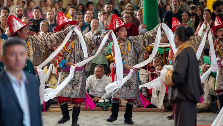 Performers from the Tibetan Institute of Performing Arts (TIPA) in ornate costumes dance and sing on each side of the aisle as His Holiness the Dalai Lama arrives to attend a Long Life Prayer at the Main Tibetan Temple in Dharamsala, HP, India on June 11, 2024. Photo by Tenzin Choejor