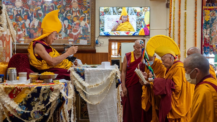 Samdhong Rinpoché handing His Holiness the Dalai Lama a long-life arrow during the Long Life Prayer at the Main Tibetan Temple in Dharamsala, HP, India on June 11, 2024. Photo by Tenzin Choejor